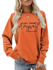 Detail of orange crewneck sweatshirt with Love Them Anyway Luke 23:34 print and ribbed cuffs