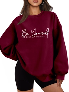 Detail of burgundy fleece sweatshirt featuring white Be Yourself slogan print
