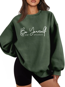 Close-up of Be Yourself print on dark green oversized sweatshirt with ribbed crew neck