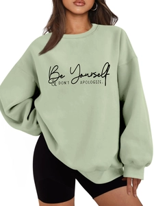 Detail of oversized sage green sweatshirt with Be Yourself text print and ribbed cuffs