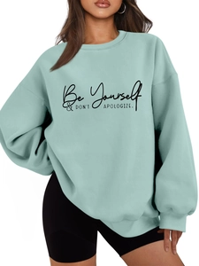 Detail of mint green oversized sweatshirt with Be Yourself & Don't Apologize slogan print