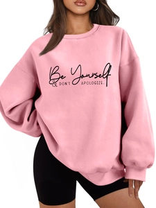 Detailed close-up of pink oversized sweatshirt with Be Yourself printed text design
