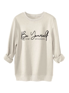 Close-up of Be Yourself slogan print on cream sweatshirt with ribbed crewneck details