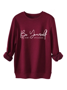 Close-up of 'Be Yourself' slogan print on burgundy fleece sweatshirt for women