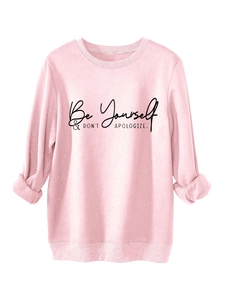 Detail of pink crewneck sweatshirt featuring Be Yourself embroidered text and ribbed cuffs