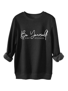 Detail of black fleece sweatshirt with white Be Yourself & DON'T APOLOGIZE text print