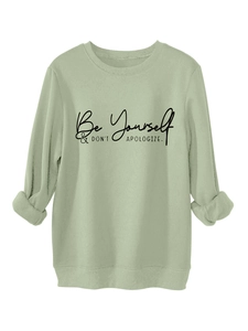 Detail of sage green sweatshirt with Be Yourself slogan print and ribbed cuffs