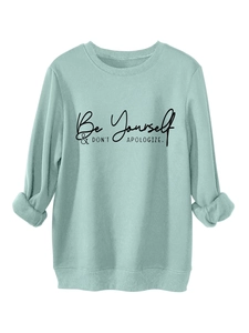 Detail of mint green sweatshirt featuring Be Yourself & DON'T APOLOGIZE printed text