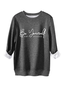 Detail of dark grey sweatshirt featuring white slogan print and soft fleece lining texture