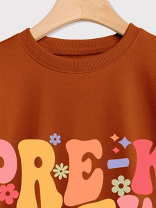 Detail of ribbed crewneck and colorful Pre-K graphic on caramel brown sweatshirt