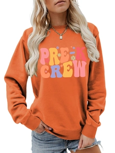 Detailed view of the Pre-K Crew print and ribbing on an orange long-sleeve sweatshirt