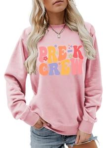 Detailed close-up of pink long-sleeve crewneck with colorful Pre-K Crew print and floral art