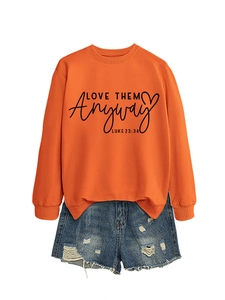 Detail of orange crewneck sweatshirt with Love Them Anyway print and denim shorts
