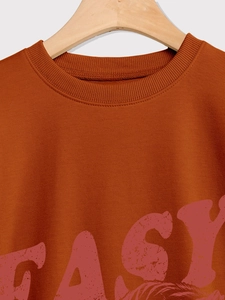 Detail of rust-red crewneck sweatshirt showing ribbed neckline and EASY letter print