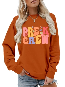 Close-up of bright orange Pre-K Crew sweatshirt with retro bubble lettering and stars