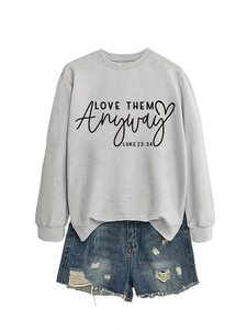 Detail of grey crewneck sweatshirt with Love Them Anyway print and ripped denim shorts
