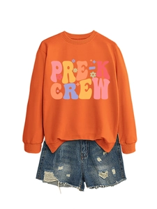 Detail of orange crewneck sweatshirt with PRE-K CREW print and distressed denim shorts
