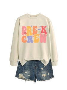 Detail of Pre-K Crew cream sweatshirt paired with distressed blue denim shorts