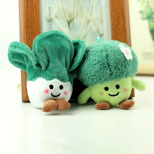 Close-up of cute plush broccoli and cabbage keychains with embroidered smiling faces