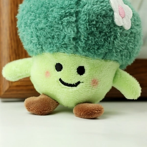 Macro detail of broccoli plush toy with embroidered smiling face and soft fabric texture