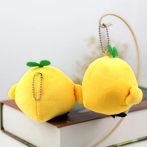 Detail of yellow plush chick pendant with soft texture and green leaf on metal chain