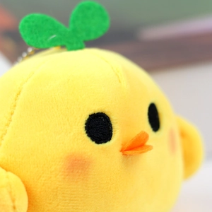 Detailed macro shot of yellow plush chick pendant with soft texture and metal bead chain