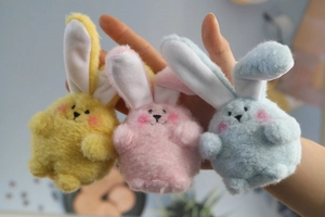 Close-up of colorful plush bunny charms in yellow, pink and blue for wedding gifts