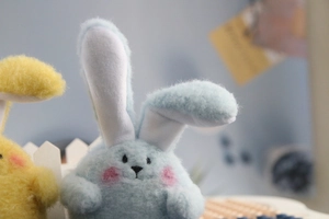Close-up of soft curly plush bunny toys in light blue and yellow for wedding gifts