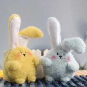Cute yellow and blue plush bunny dolls for wedding gifts and events sitting on blue base