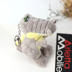 Dettaglio del portachiavi a coccodrillo di peluche grigio con pancia gialla e anello
