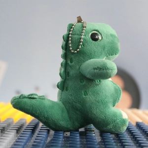 Detailed view of a green plush dinosaur keychain with soft texture and metal bead chain