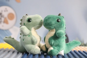 Close-up of green plush dinosaur keychains with soft texture and bead chains
