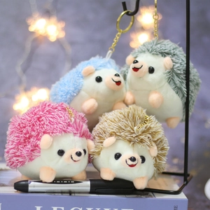 Detailed view of four colorful plush hedgehog keychains in blue, green, pink, and brown