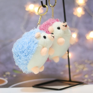Detailed view of pink and blue plush hedgehog keychains hanging on a metal display stand