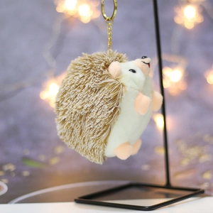 Detail of cute hedgehog plush keychain featuring soft brown faux fur and a gold metal clip