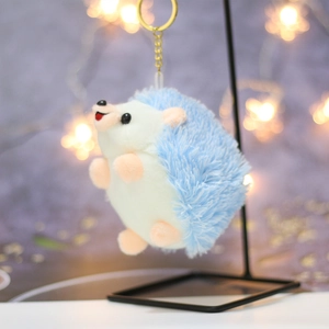 Detail of light blue hedgehog plush keychain featuring soft fur and golden metal ring