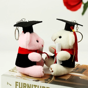Gros plan d'ours en peluche de graduation roses et blancs avec toques et porte-clés