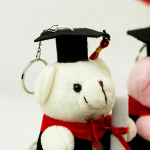 Détail macro du porte-clés ours en peluche blanc de remise de diplôme avec toque et gland