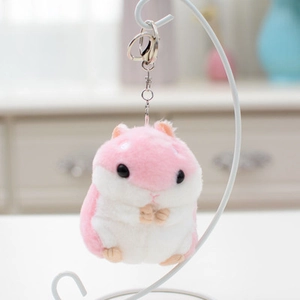 Dettaglio del ciondolo a forma di criceto in peluche rosa e bianco con clip in metallo