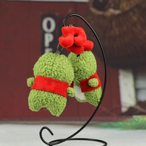 Vue détaillée du porte-clés grenouille en peluche verte avec bavoir rouge et texture