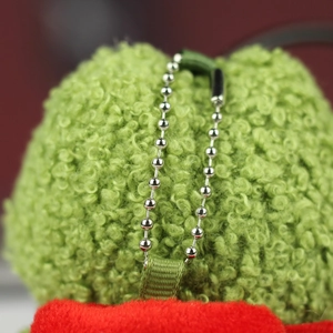 Détail d'un pendentif grenouille en peluche bouclée verte avec chaîne à billes argentée