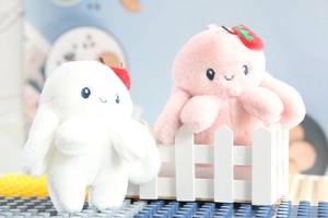 Close-up of pink and white plush octopus pendants with cute strawberry hat decorations