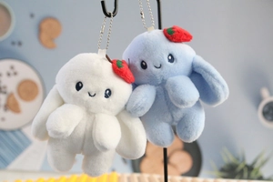 Detail of white and blue plush bunny charms with strawberry accents and metal ball chains