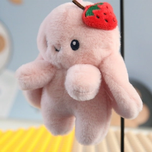 Close-up of pink plush rabbit pendant with strawberry embroidery and soft long fur