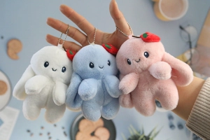 Detailed view of plush bunny charms in white, blue and pink with metal ball chains