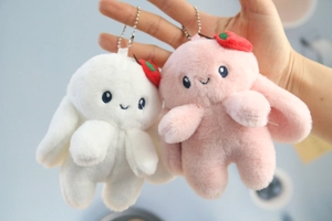 Detail of plush rabbit keychains with cute strawberry charms and silver bead chains