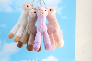 Close-up of four colorful plush alpaca keychains with durable metal rings for bags