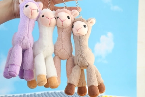 Detailed view of four colorful plush alpaca keychains with metallic ring attachments