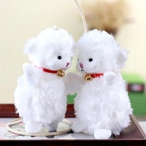 Close-up of fluffy white lamb plush keychains with red collars and golden bells