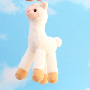 Close-up of white plush alpaca keychain with soft faux fur texture and metal hook